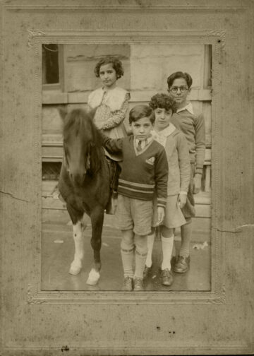 Jamila (left) and her siblings Giuseppi, Francesca, and Vincenzo posing with a horse (ca. 1930).