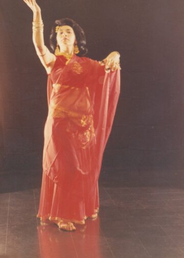 Jamila Salimpour posing with veil in a red costume made for her by her long-time friend, Bob Mackie.